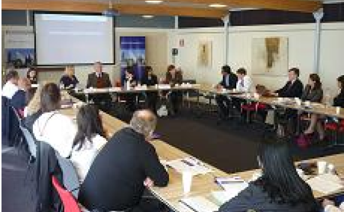 Meeting room with lots of people wearing suits