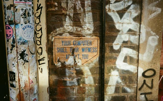 Graffiti covers a brick wall with a sign